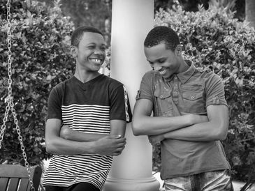 Young men smiling outdoors in community